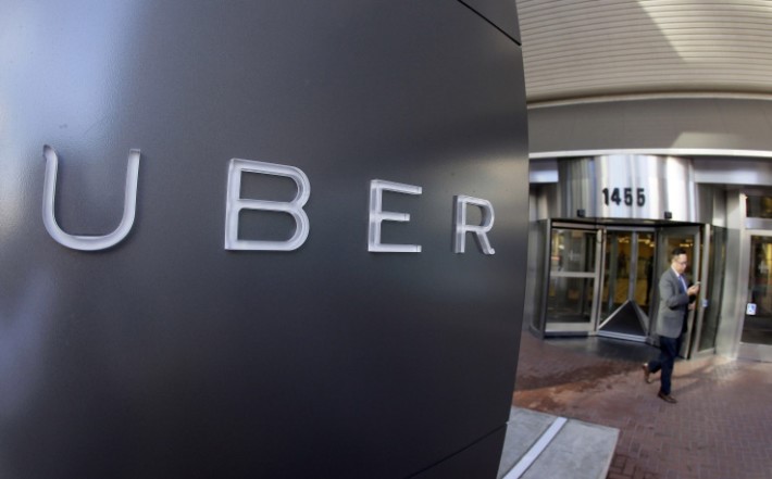 FILE - In this Dec. 16, 2015 file photo a man leaves the headquarters of Uber in San Francisco. Uber and advocates for the blind have reached a lawsuit settlement in which the ride-hailing company agrees to require that existing and new drivers confirm they understand their legal obligations to transport riders with guide dogs or other service animals. The National Federation of the Blind said Saturday, April 30, 2016, that Uber will also remove a driver from the platform after a single complaint if it determines the driver knowingly denied a person with a disability a ride because the person was traveling with a service animal. (AP Photo/Eric Risberg, File)