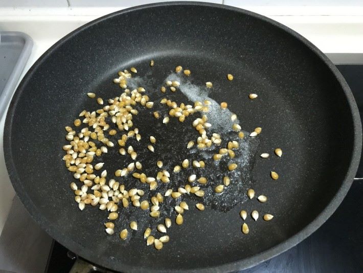 Step 1：平底鑊落油加熱，把一至兩粒粟米粒放入鑊內測試熱力，如爆了即代表油夠熱，夠熱就可以下粟米粒，同時拌勻。