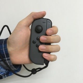 手握 Joy-Con 時保持垂直狀態，並且將拇指放於 L/R 鍵位置。