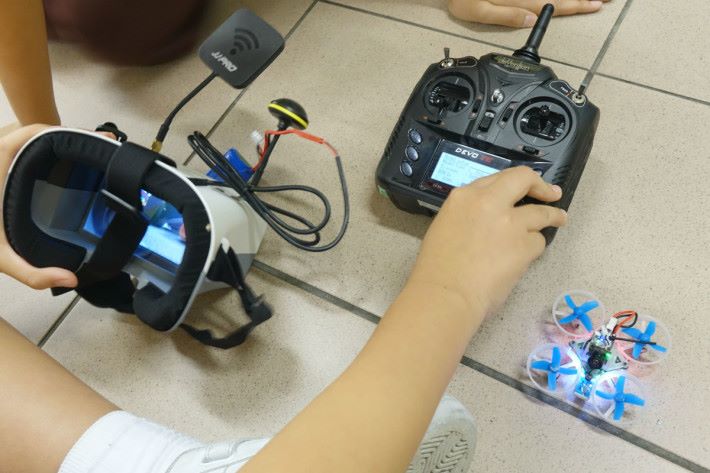 同學正在檢查 FPV 眼鏡、無人機及遙控器的設定。