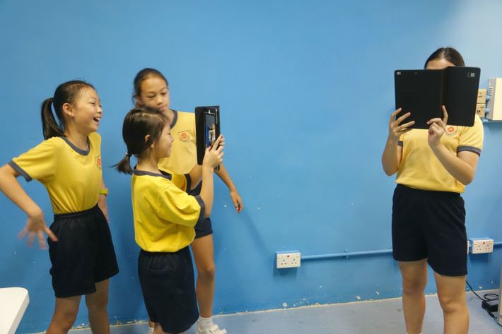 （左起）彭鈺琦及潘梓琦同學示範如何為房間拍360度全景相片。