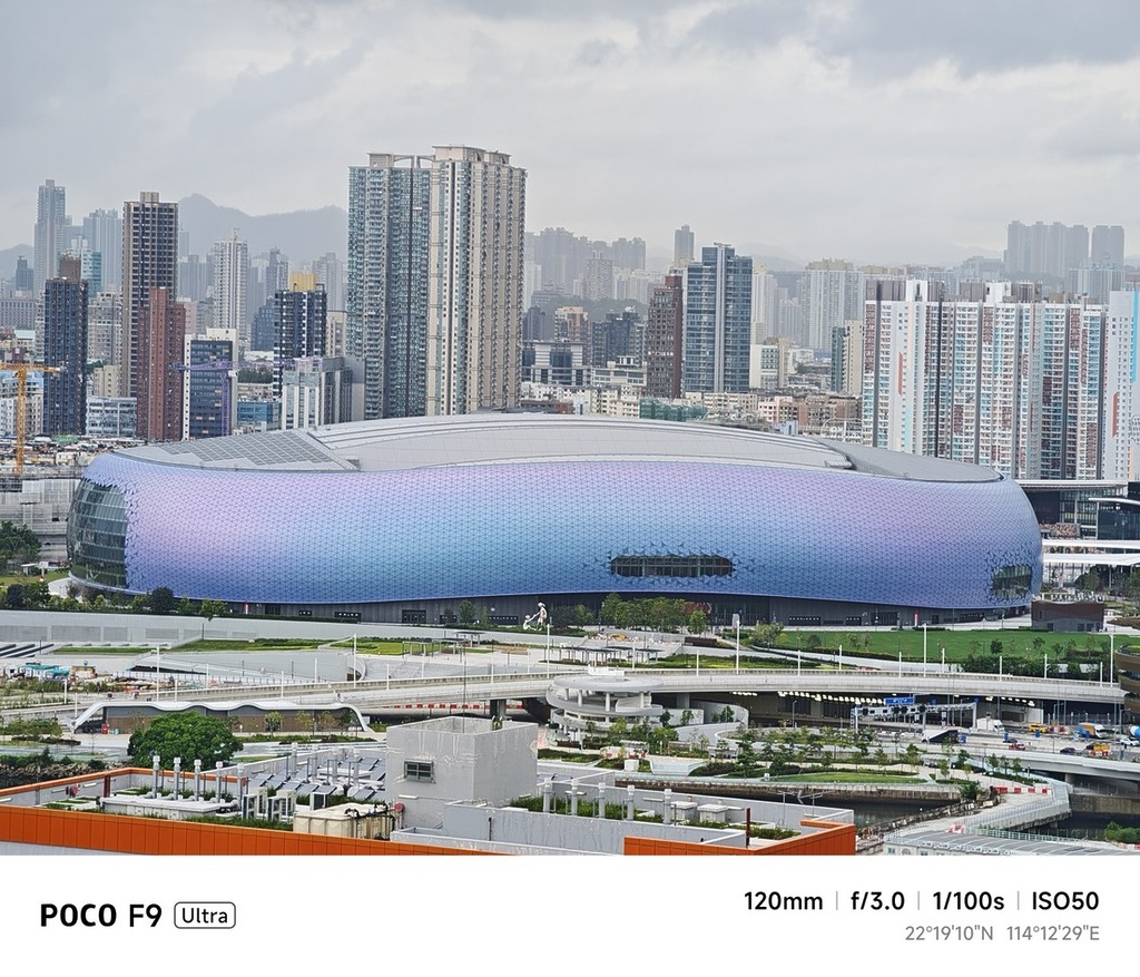 於九龍灣 Mega Box 的 Mega Sky 空中花園,以 5,000 萬像素 5 倍潛望式長焦鏡頭遠拍啟德主場館,可見體育館外牆甚為細膩,亦能完美還原其獨特漸變紫色彩,背景樓宇也能清晰入鏡,遠攝力相當不錯。